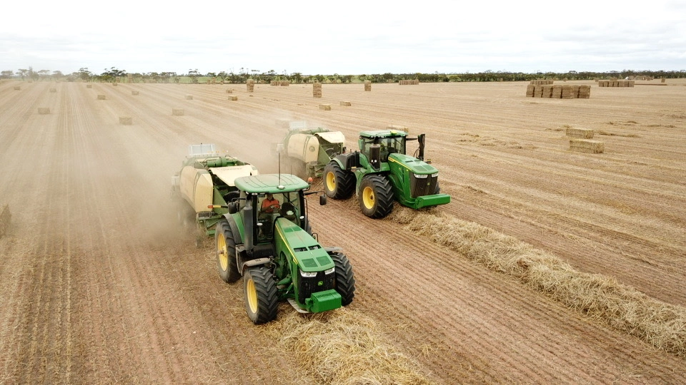 Two tractors and square balers working side by side
